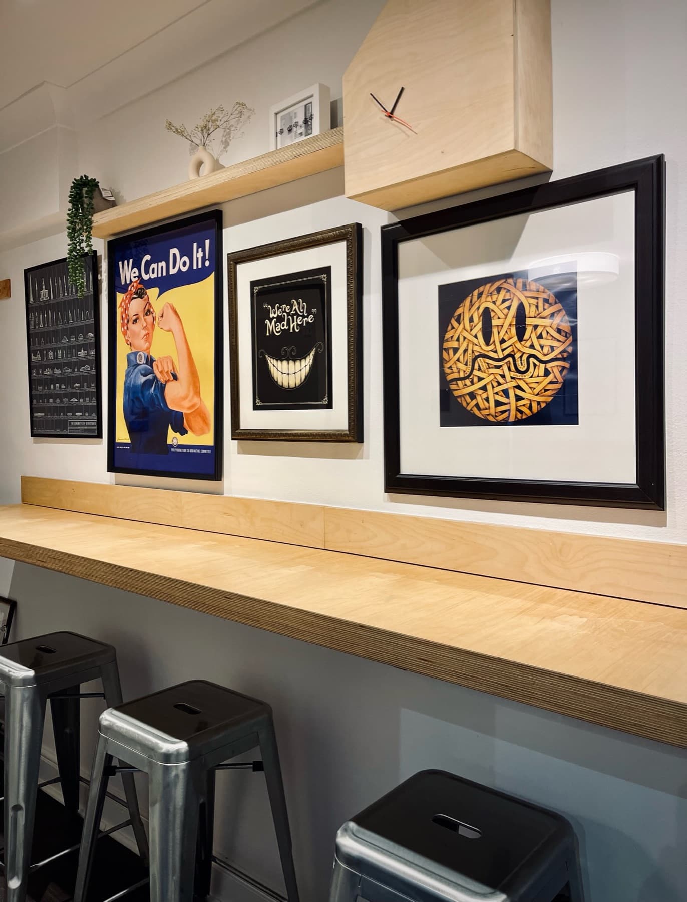 The dining bar in the hallway with stools and a gallery wall